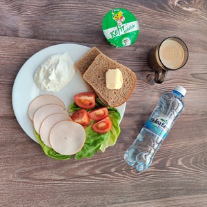Zdjęcie przedstawia Dietę z ograniczeniem łatwoprzyswajalnych węglowodanów  Chleb Graham Masło extra Kawa zbożowa z mlekiem Twarożek Kefir Pomidor Woda mineralna Szynkowa dębowa drobiowa Sałata zielona